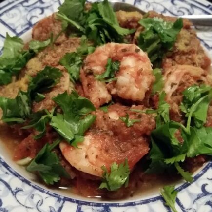 Pasta serving bowl of shrimp divolo garnished with flat leaf parsely