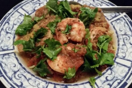 Pasta serving bowl of shrimp divolo garnished with flat leaf parsely