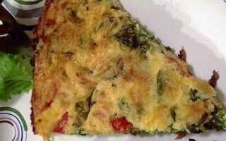 Slice of frittata on a paper plate viewed from above