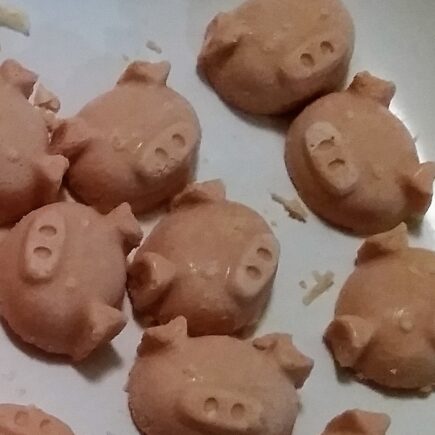 Close up of fat bombs extracted from ice trays, pig face shaped