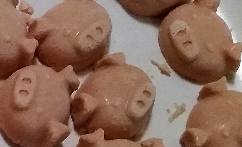 Close up of fat bombs extracted from ice trays, pig face shaped